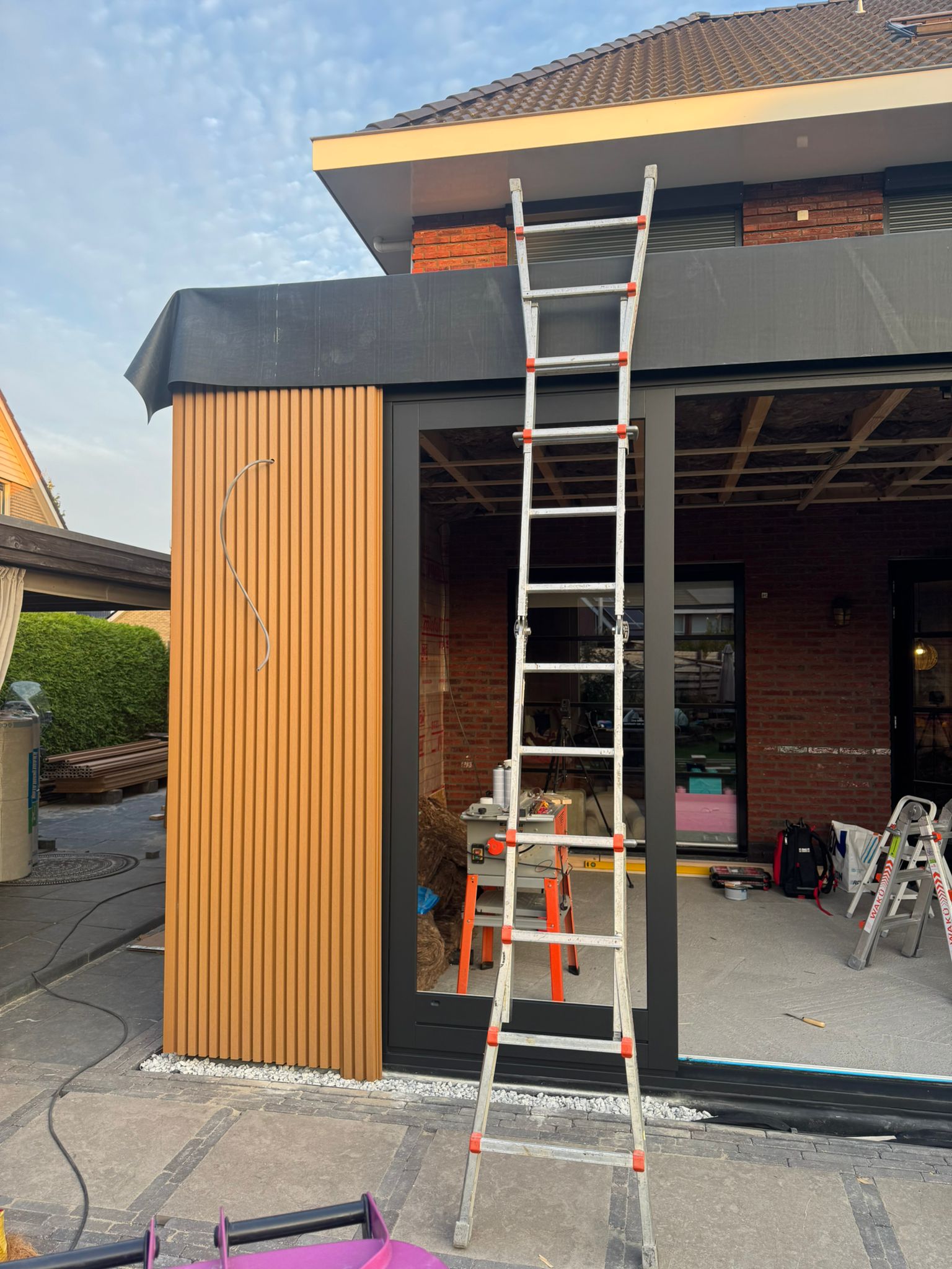 Uitbouw project met houten gevel en schuifpui